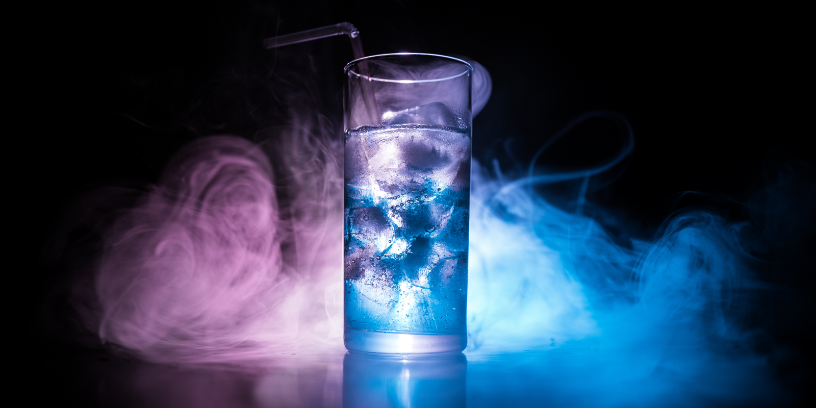 Clear glass of vodka with purple and blue fog around it